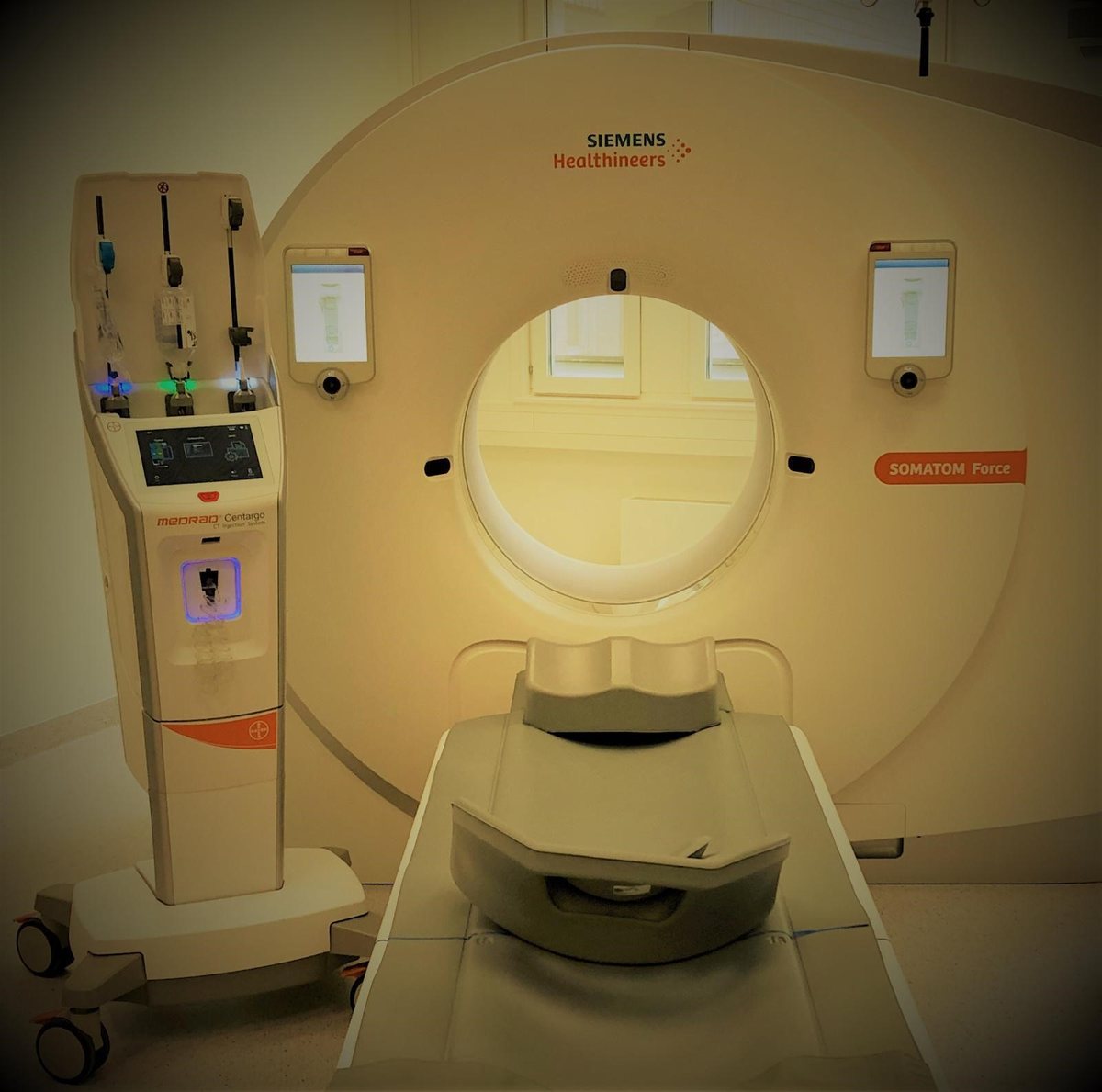 Modern CT scanner beside a Bayer MEDRAD contrast injection system