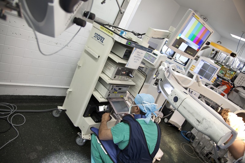 Mobile C-arm fluoroscopy unit in an operating room with monitor and endoscopy equipment