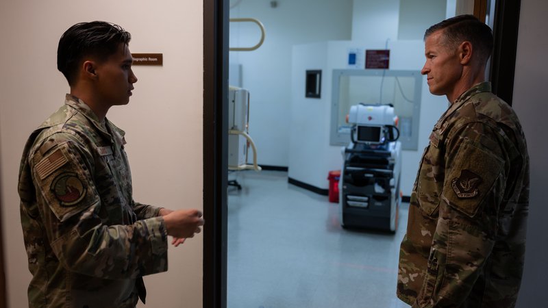 U.S. Air Force diagnostic imaging technologist provides a radiology brief to a commander, demonstrating patient communication and professional interaction in radiography